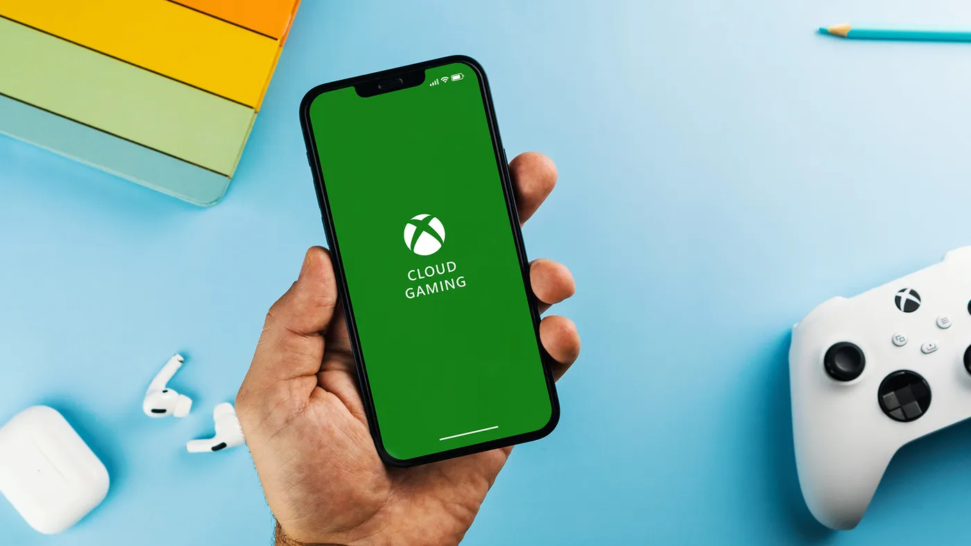 A person holding a phone with the Xbox Cloud Gaming logo on it. A person holding a phone with the Xbox Cloud Gaming logo on it.