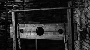 A black and white photograph of a medieval stock in a dungeon A black and white photograph of a medieval stock in a dungeon