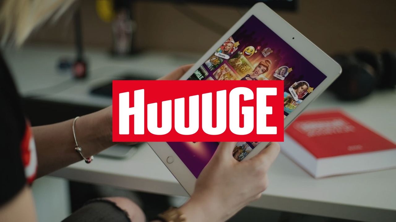 The Huuuge logo overlaid on a photograph of a mobile gamer holding an iPad The Huuuge logo overlaid on a photograph of a mobile gamer holding an iPad