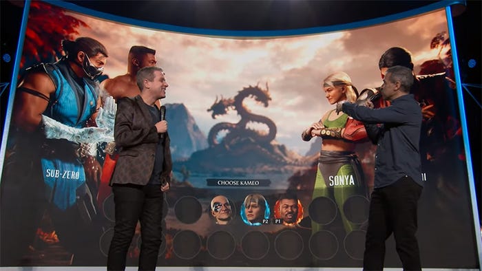 Ed Boon and Geoff Keighley stand in front of a display of Mortal Kombat 1's Kameo Selection screen.