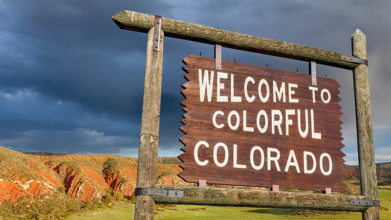 A photograph of a sign that says "Welcome to Colorful Colorado."