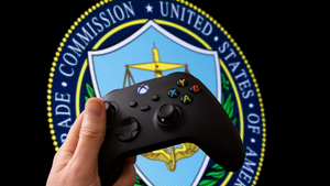 A person holds an Xbox controller in front of the FTC logo. A person holds an Xbox controller in front of the FTC logo.