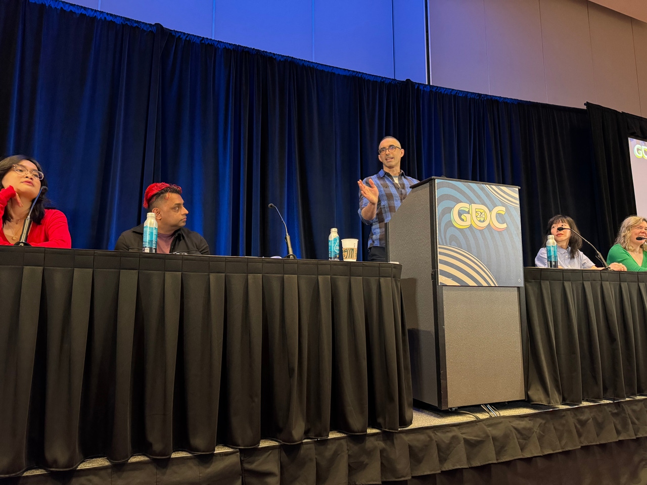 Developers speak at the advocacy microtalks GDC podium Developers speak at the advocacy microtalks GDC podium