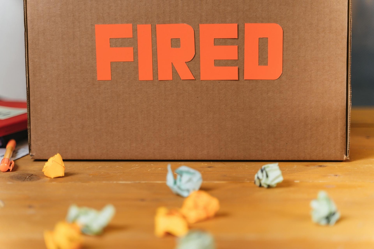 The word "fired" on a box with folded up papers The word "fired" on a box with folded up papers