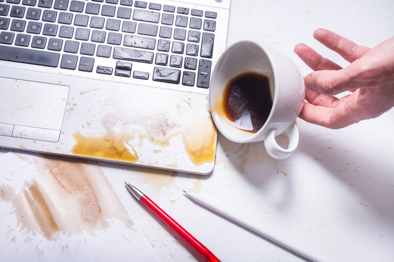 Coffee spilling on a laptop keyboard Coffee spilling on a laptop keyboard