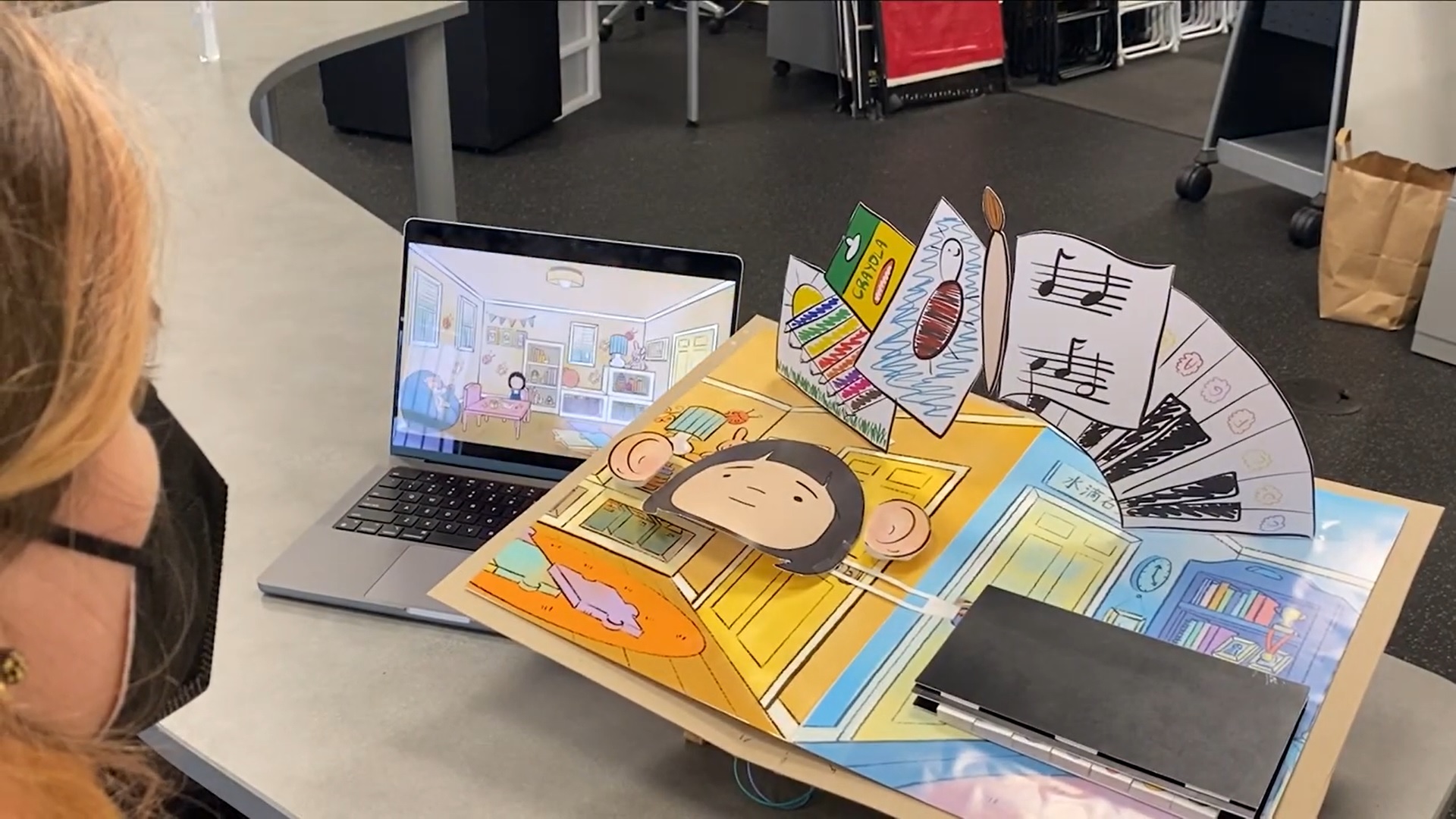 a person looking at an intricate pop-up book controller and game about a young child