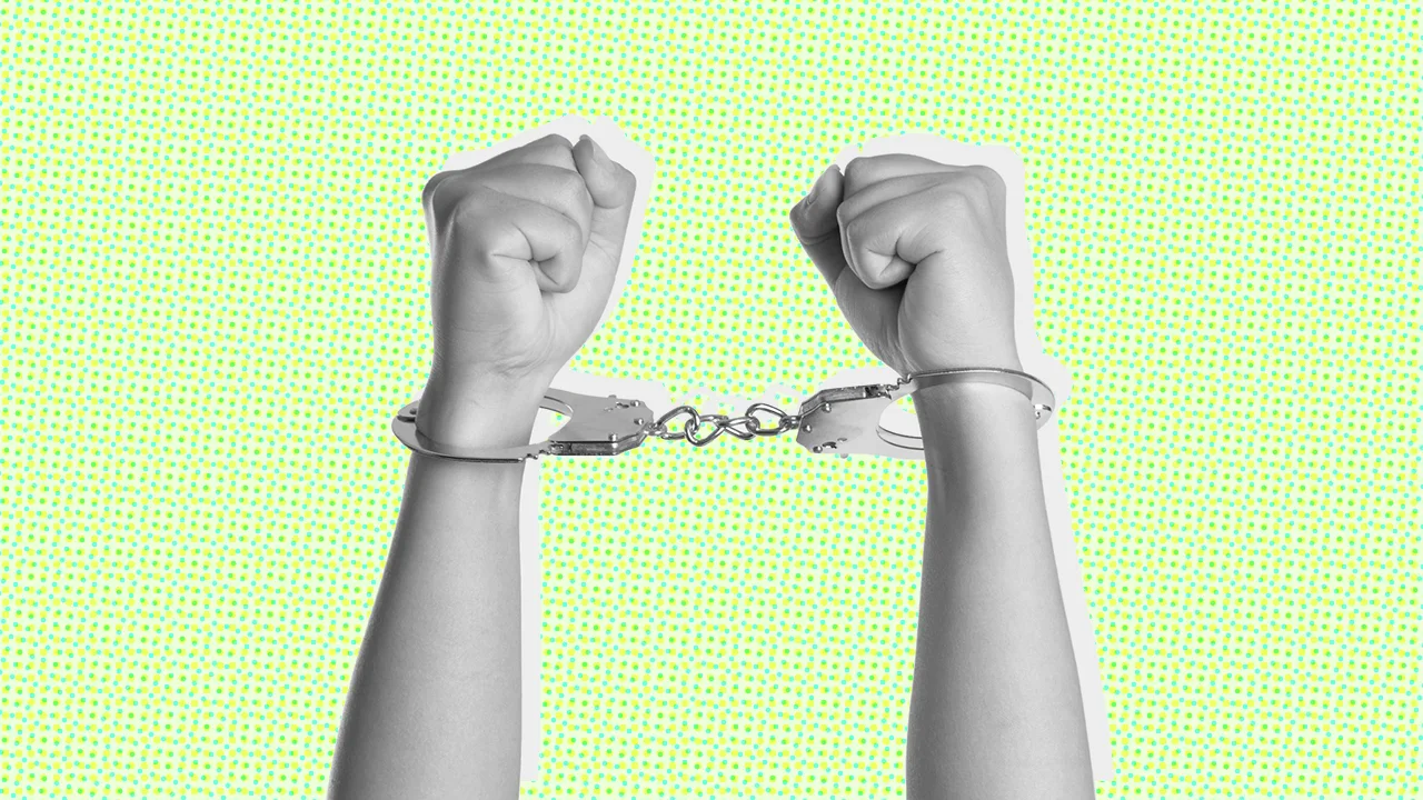 A black and white photograph of arms in handcuffs on a green background A black and white photograph of arms in handcuffs on a green background