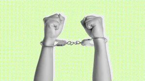 A black and white photograph of arms in handcuffs on a green background A black and white photograph of arms in handcuffs on a green background