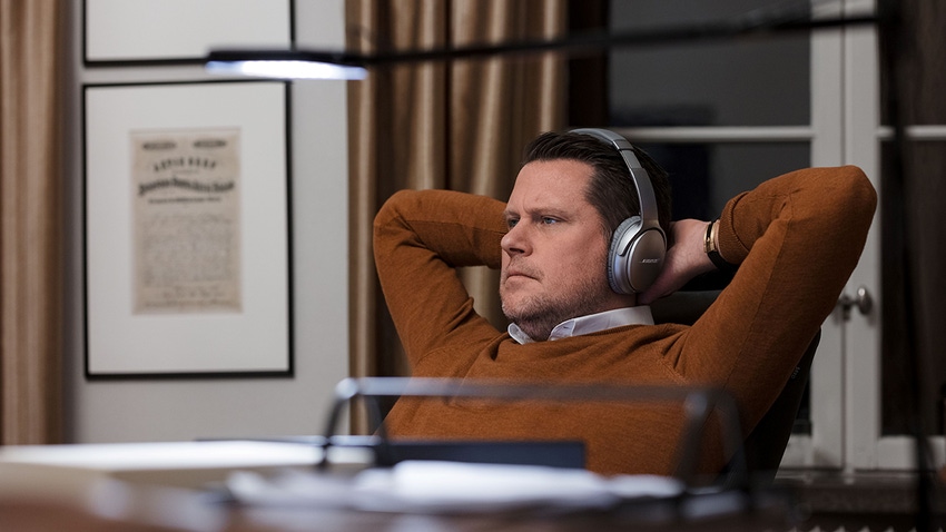 A picture of Embracer CEO Lars Wingefors sat at his desk wearing headphones