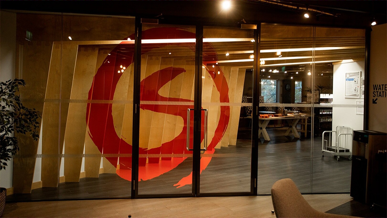 A photo of the Sumo logo on a window in the company office A photo of the Sumo logo on a window in the company office