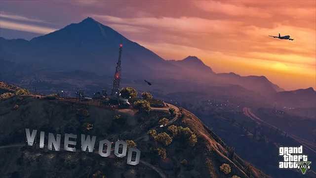 A screenshot from Grand Theft Auto 5, overlooking Mount Chiliad at sunset, with the Vinewood sign and a plane visible. A screenshot from Grand Theft Auto 5, overlooking Mount Chiliad at sunset, with the Vinewood sign and a plane visible.