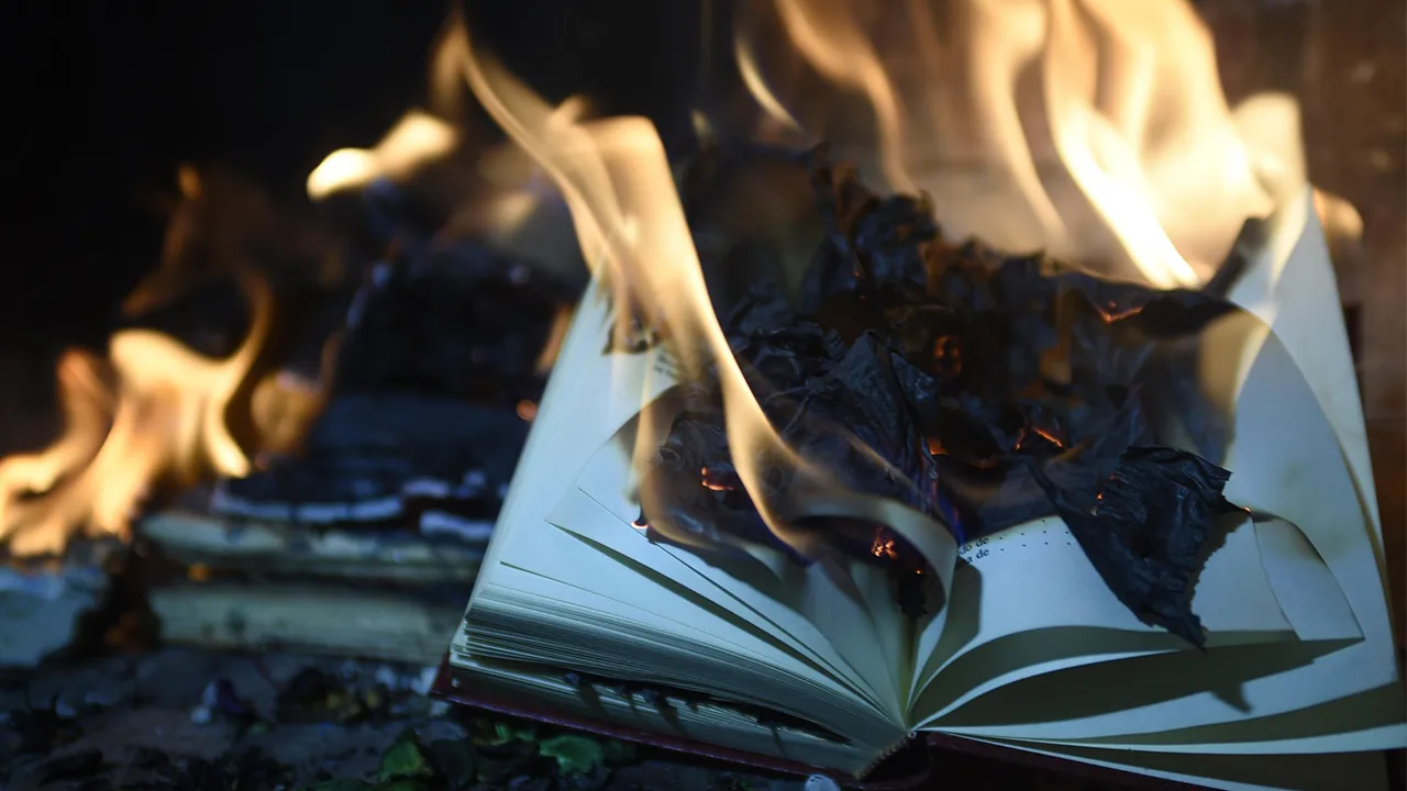 A burning book that has been tossed on the ground A burning book that has been tossed on the ground