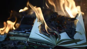 A burning book that has been tossed on the ground A burning book that has been tossed on the ground