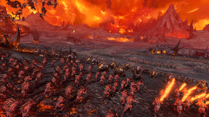 Two large beast armies clash on a firey hellscape battleground.
