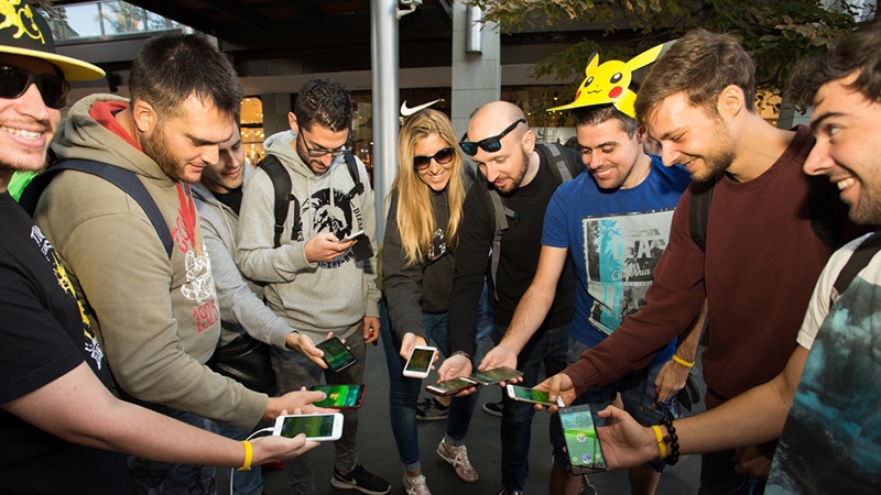 A group of Pokemon Go players gather in a semicircle. A group of Pokemon Go players gather in a semicircle.