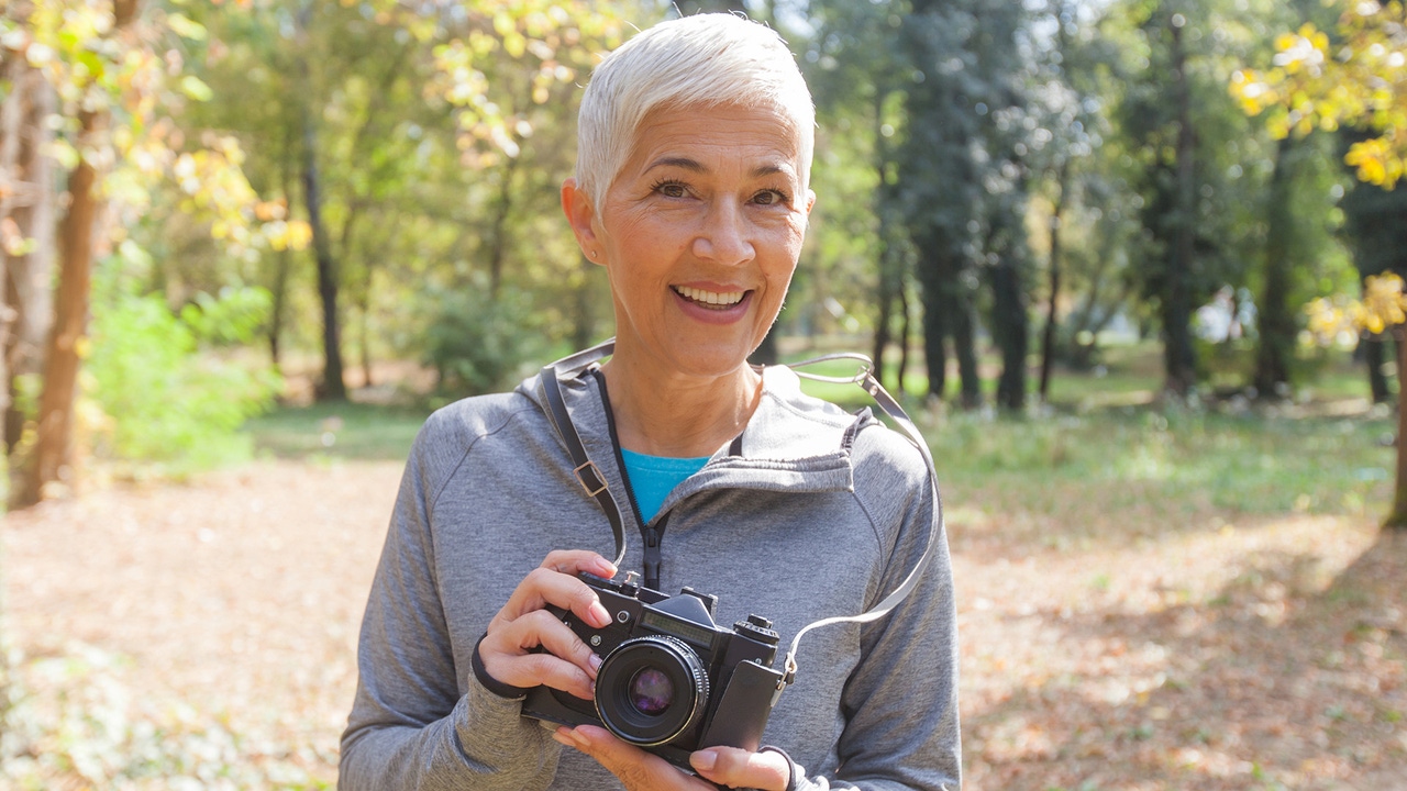 An older woman smiles at the camera, holding one of her own. An older woman smiles at the camera, holding one of her own.