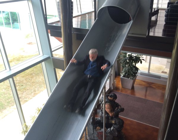 Donald Norman sliding down a slide past a statue of Marcus Fenix