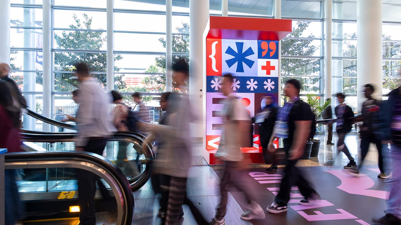 Blurred figures pass through the halls of Moscone West as GDC signage lingers in the background. Blurred figures pass through the halls of Moscone West as GDC signage lingers in the background.