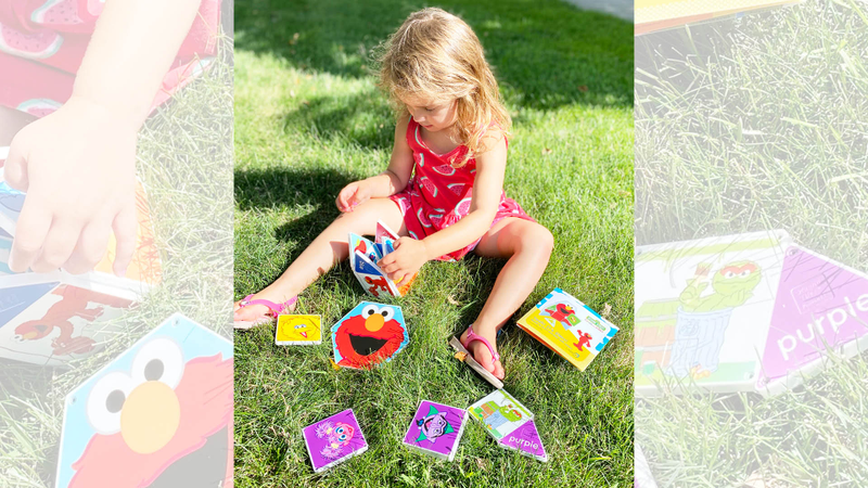 Child playing outdoors with Elmo tiles, CreateOn