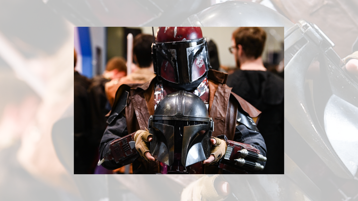 A Cosplayer holds a Mandalorian Battle Damaged Helmet Accessory at day 2 of Star Wars Celebration Europe.