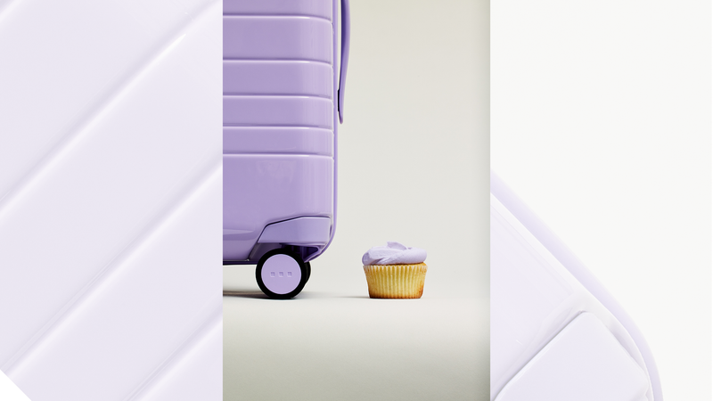 Monos purple luggage alongside Magnolia Bakery's purple icing. 