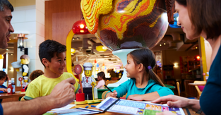 Promotional image of a family eating at a Merlin Entertainment location