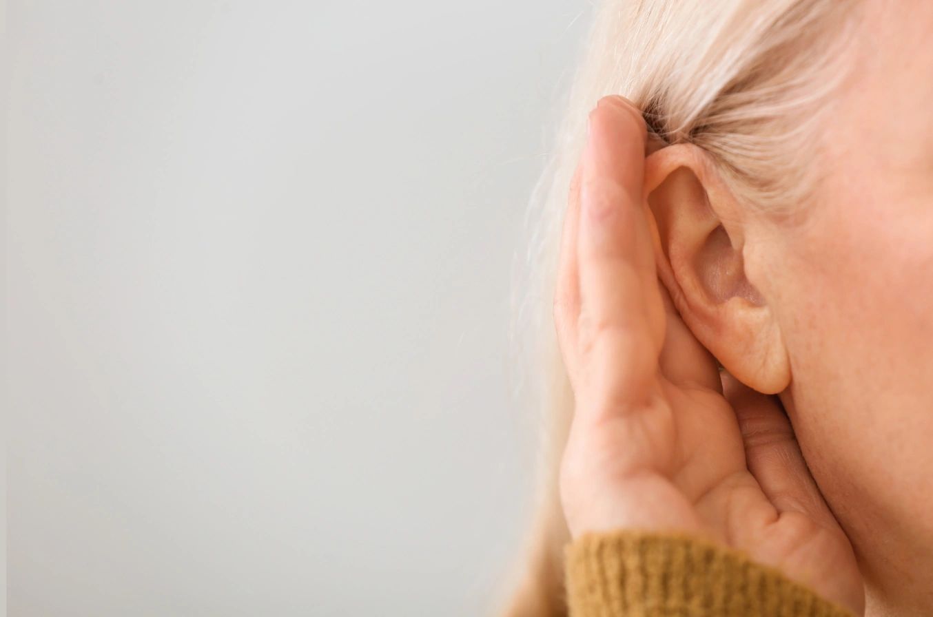 frau-haelt-hand-neben-ihr-ohr