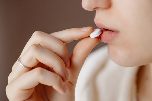 beautiful-young-woman-taking-pill-500.jpg