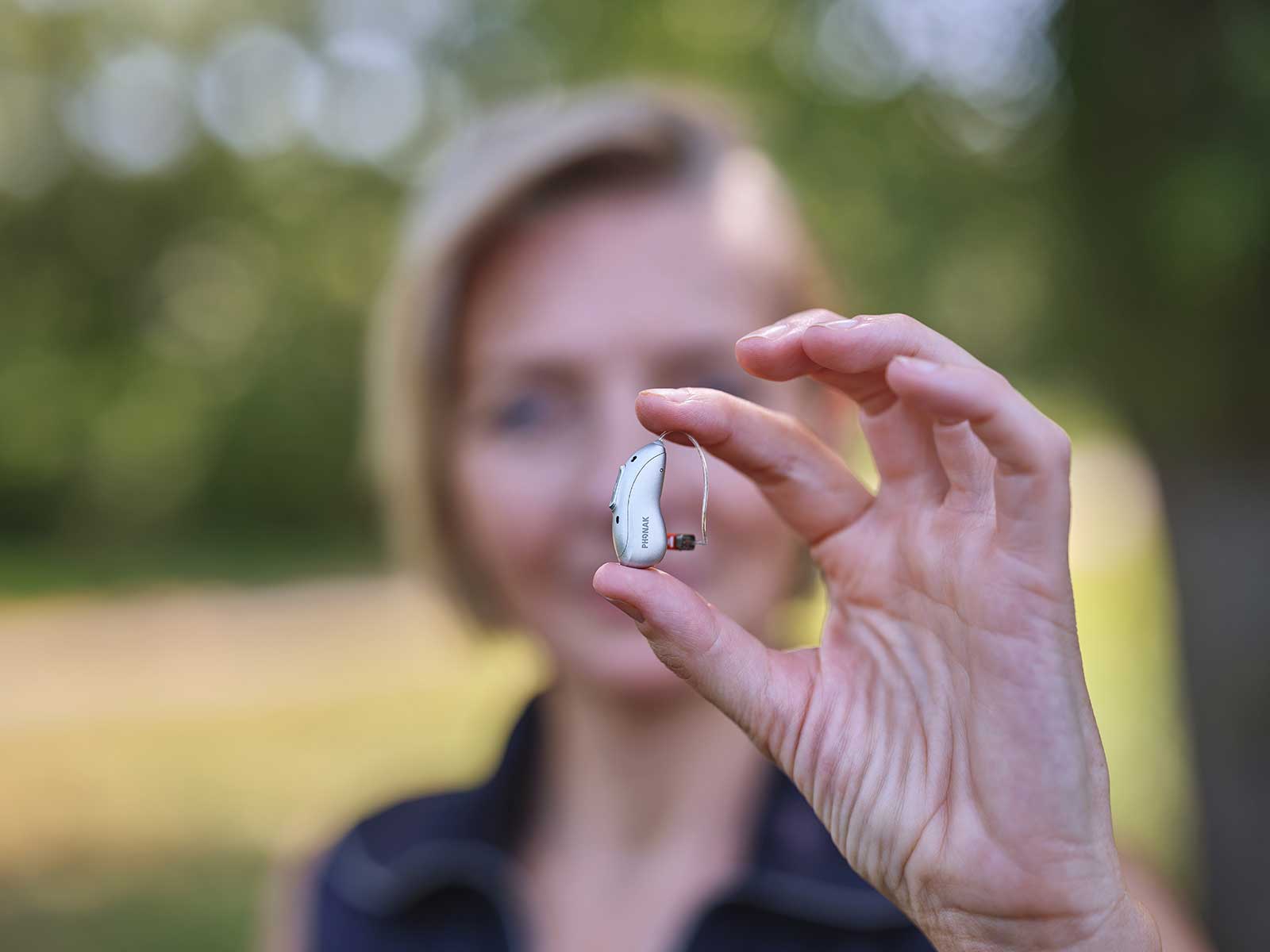 eon-close-up-hearing-aid-held-fingers.jpg