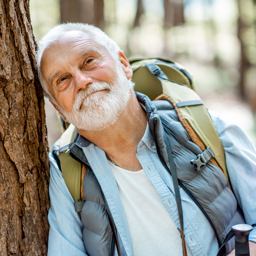 man-leaning-on-tree-on-hike.png