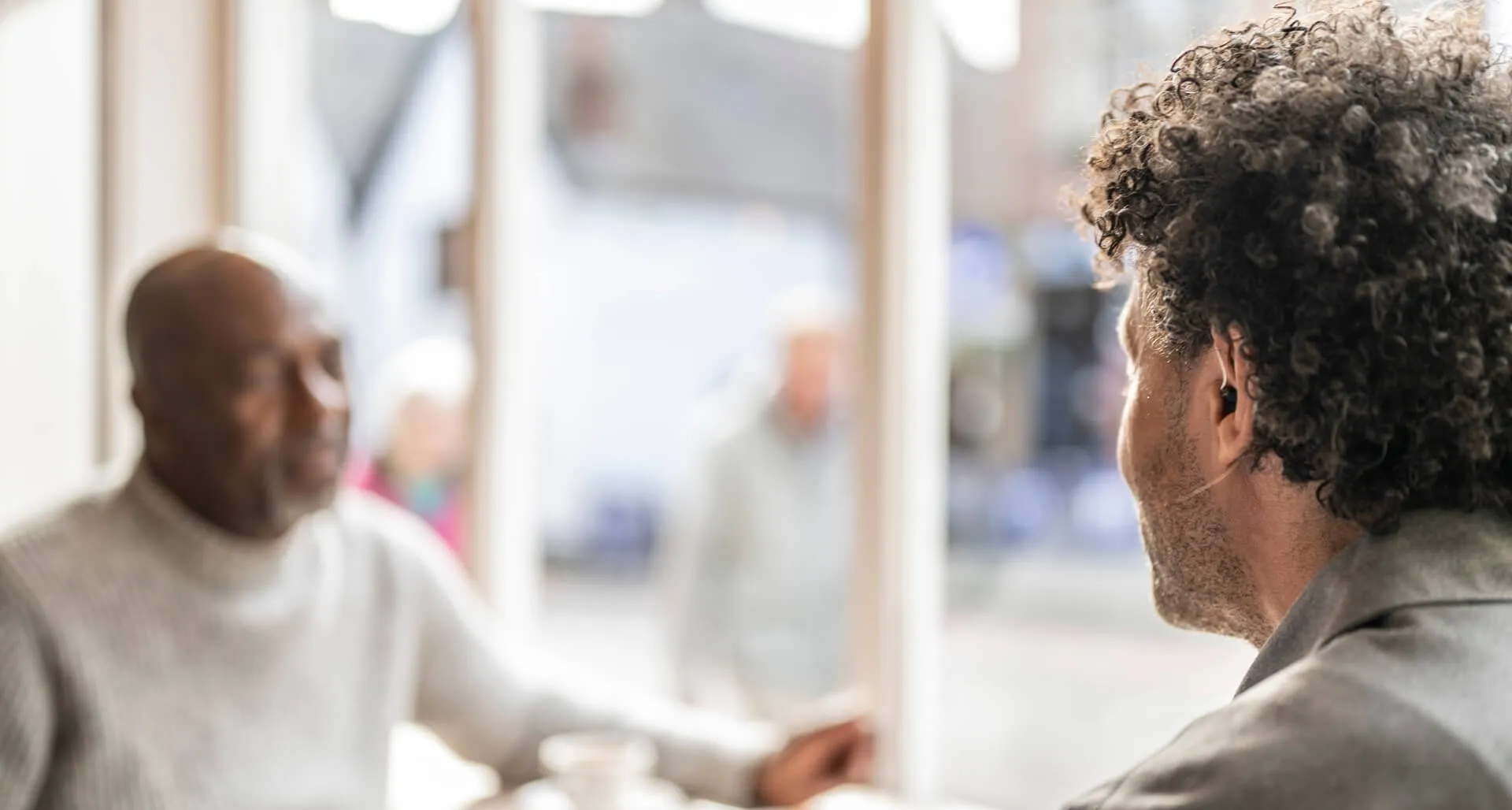 man-wearing-hearing-aid-in-cafe-desktop-banner.jpg