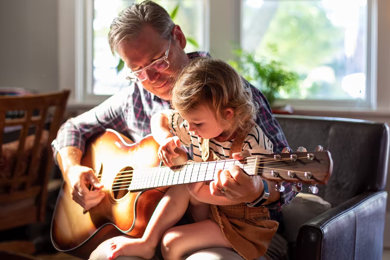 man teaching child guitar.avif