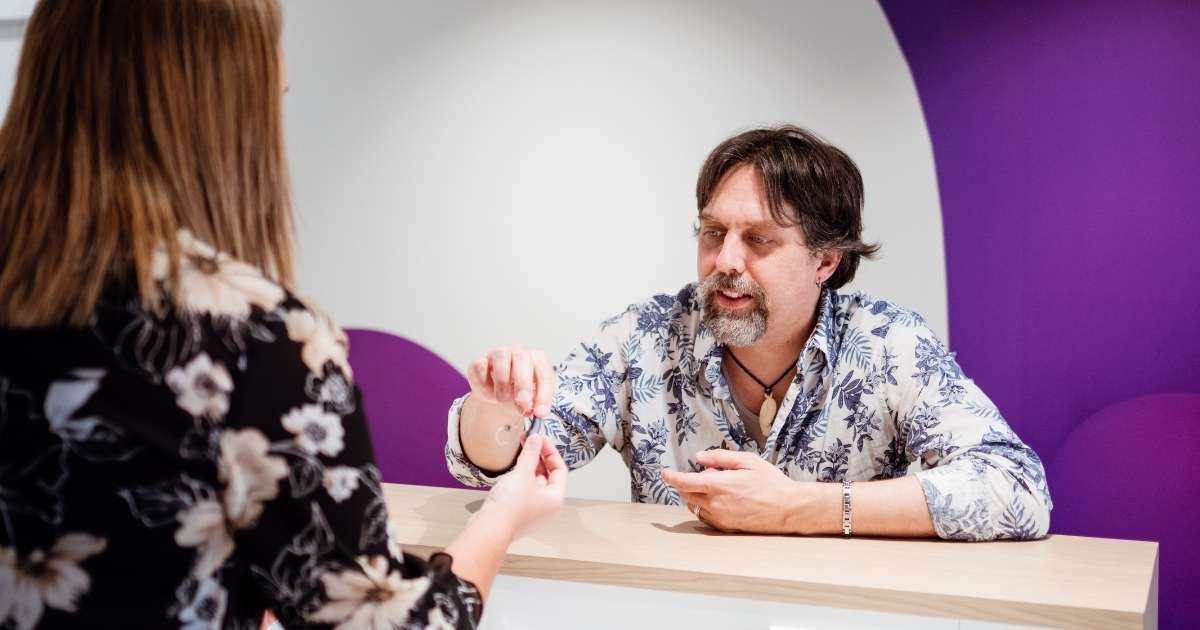 man receiving hearing aids to assist tinnitus.jpg