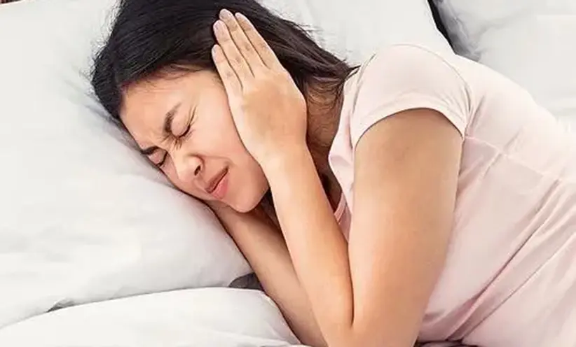 geers-hoergeraete-junge-frau-haelt-sich-die-ohren-im-bett-zu.webp