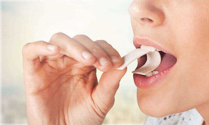 woman-putting-chewing-gum-in-mouth-min.jpg
