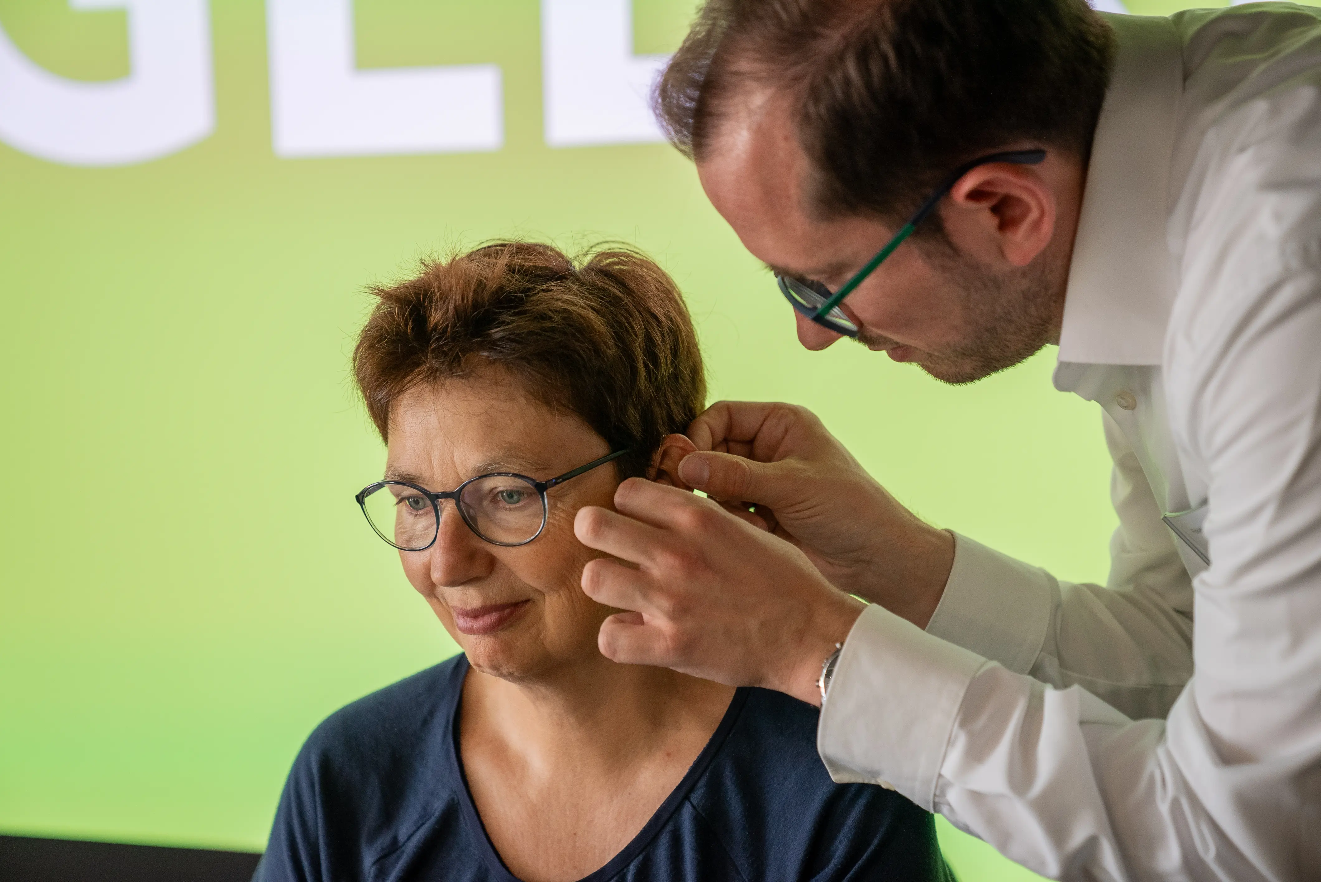 hoergeraeteakustiker-schaut-frau-ins-linke-ohr.webp