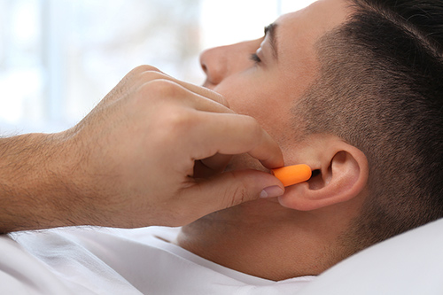 man-inserting-foam-ear-plugs-500.jpg