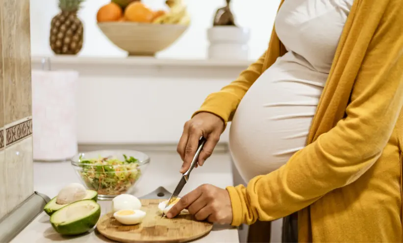 Schwangerer Frau richtet sich ein Essen.webp