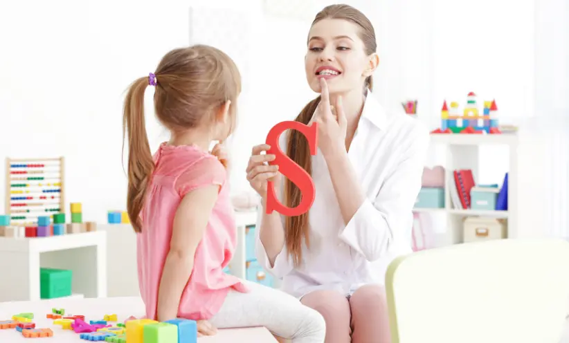 Logopädien lernt einem Kind die Aussprache von dem Buchstaben S.webp