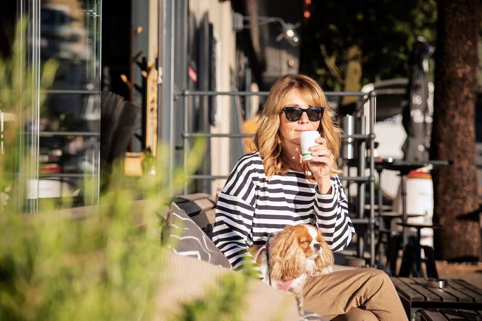 woman sipping coffee with her dog.avif