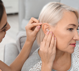 332x300-putting-hearing-aid-in.jpg