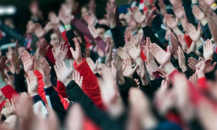 fussball-stadion-fans-haende.webp