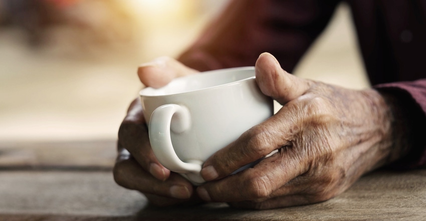 elderly hands holding a cup of coffee.jpg