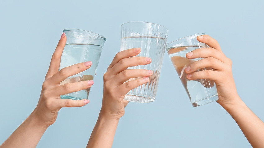 people holding water in glasses