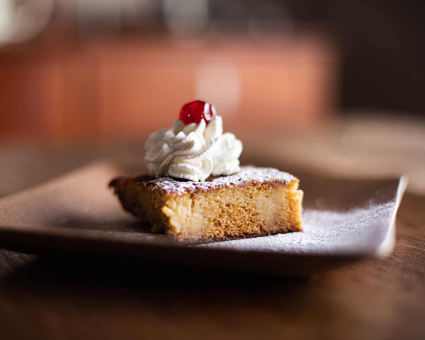 Afrikanisches Essen: Malva-Pudding mit Creme und roter Kirsche