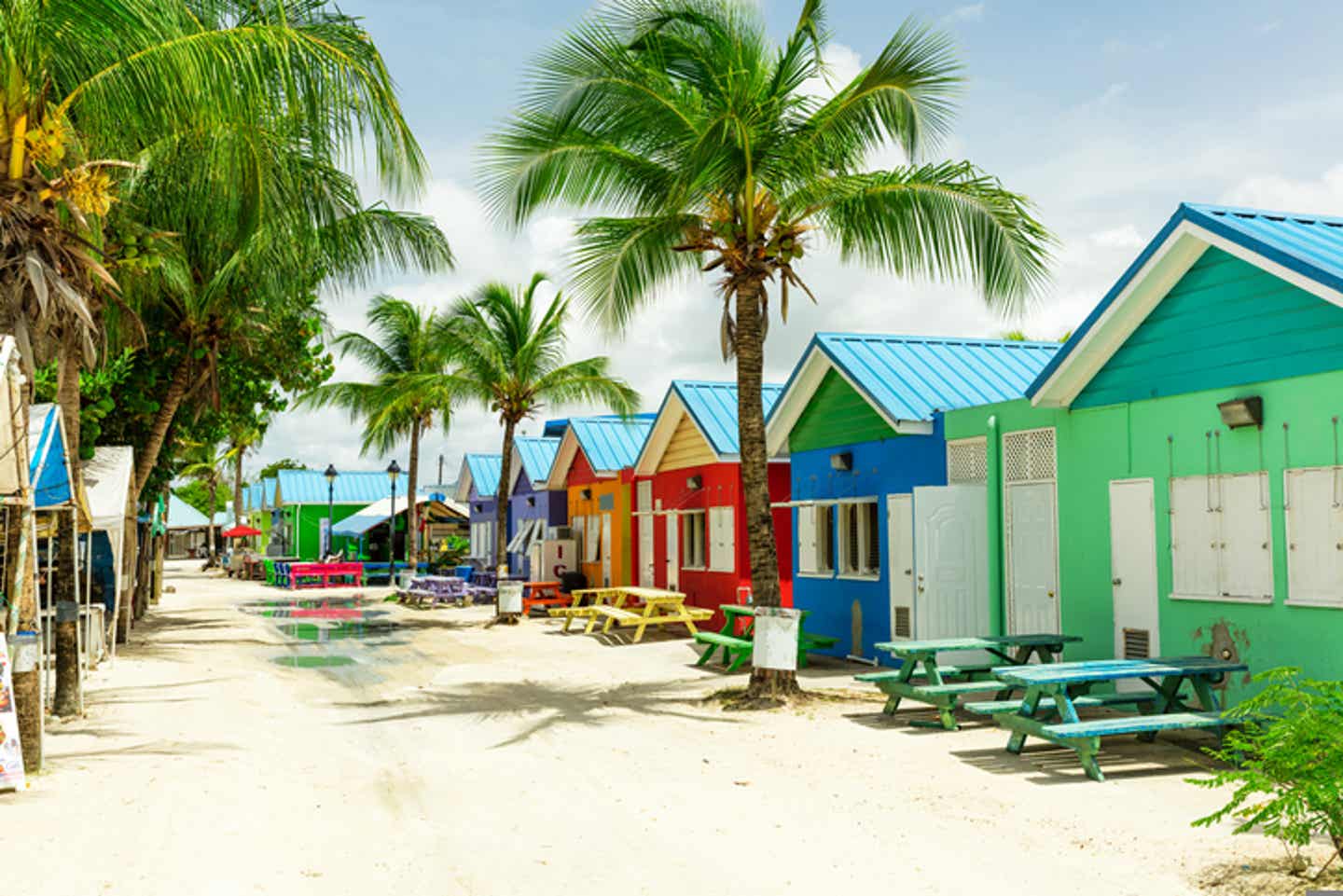 Währungen der Karibik: bunte Strandhäuser auf Barbados