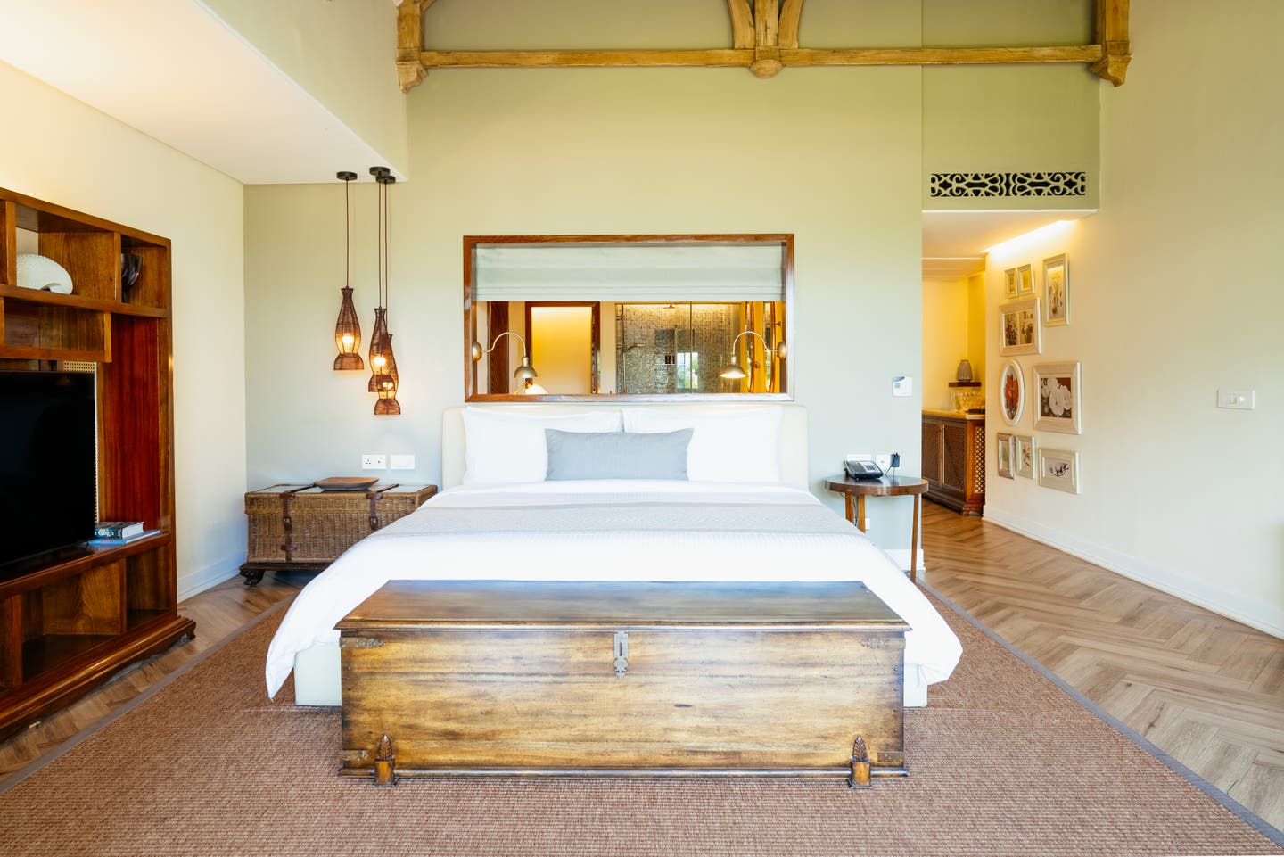 Doppelbett und halb offenes Bad in einer Heritage Beach Junior Suite des Resorts