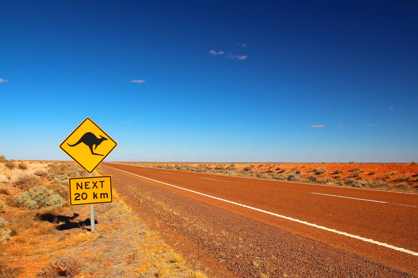 Rundreisen Australien und Neuseeland: Känguru-Warnschild an einer Straße im australischen Outback