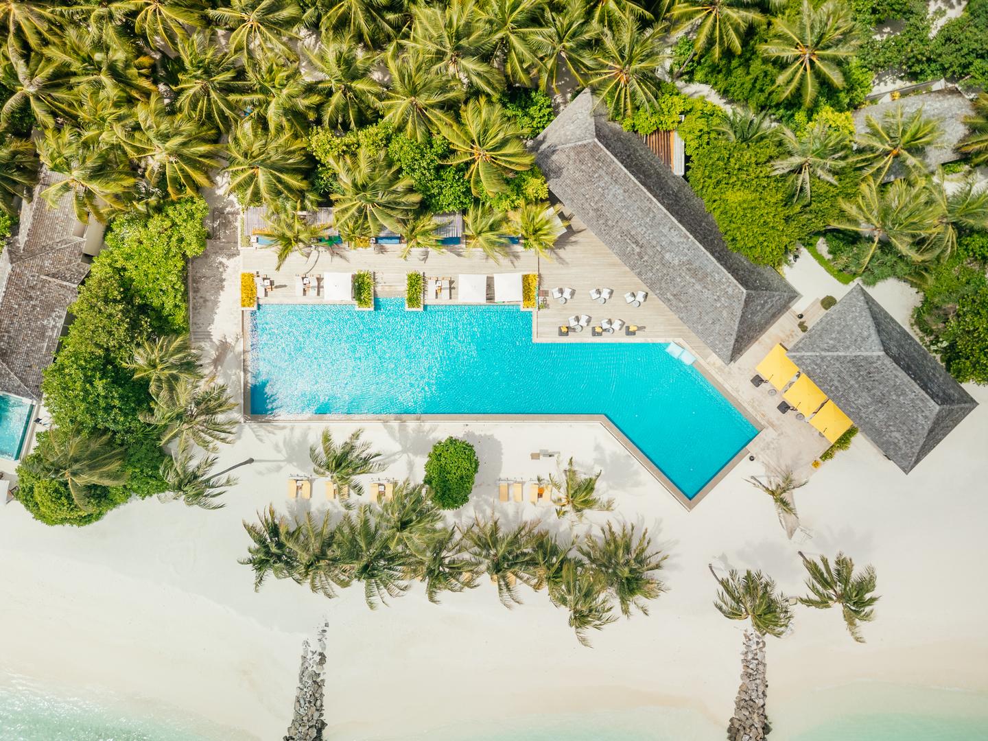 Topshot einer Drohne mit dem großen Hotelpool im Zentrum