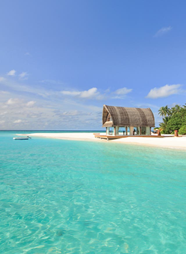 Mehr Infos hier Türkisblaues Wasser und ein weißer Sandstrand mit Hütte und einigen Palmen